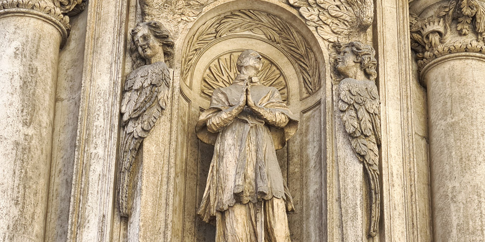 Der heilige Karl Borromäus im Gebet, eingerahmt von skulptierten Engeln
