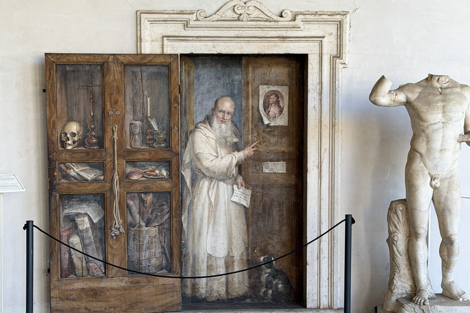 Trompe-l’œil-Fresko eines Kartäusermönchs an einer gemalten Scheintür von Filippo Balbi im Kreuzgang der Diokletiansthermen in Rom