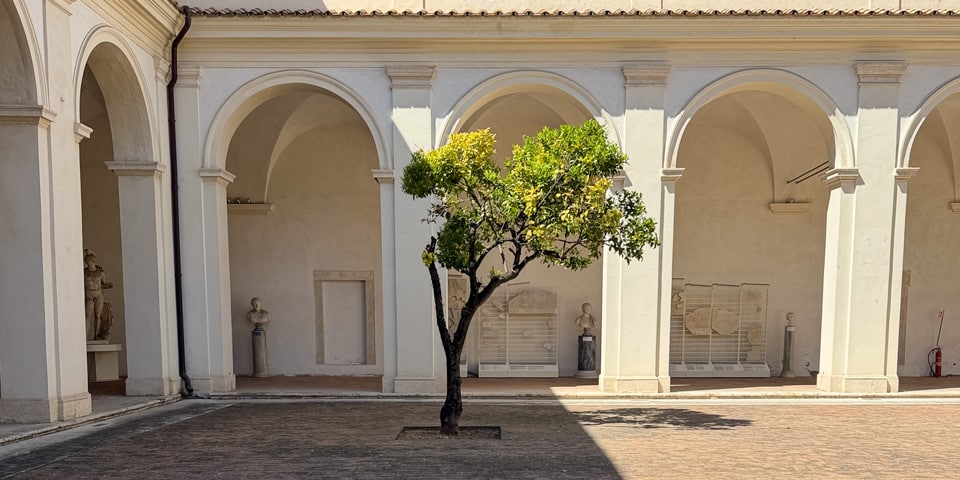 Kleiner Kreuzgang mit antiken Büsten und einem Zitronenbaum im Museo Nazionale Romano in den Diokletiansthermen in Rom