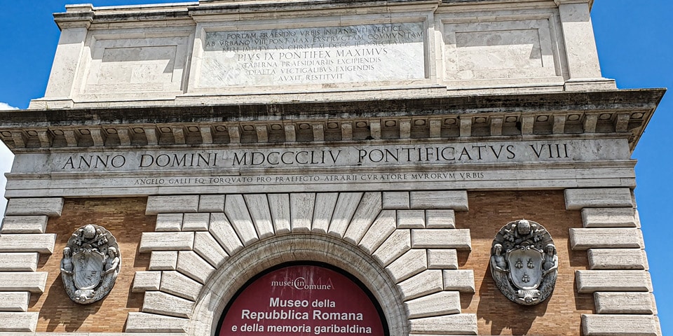 Lateinische Inschriften und päpstliche Wappen an der Porta San Pancrazio